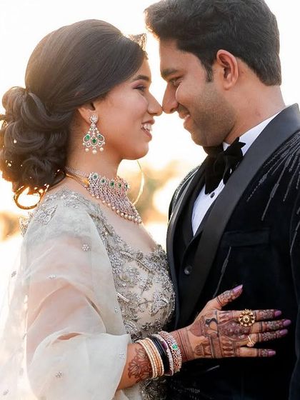 A classic, romantic portrait taken during the golden hour. The soft light and close embrace create a feeling of warmth and intimacy for this couple in their reception attire.