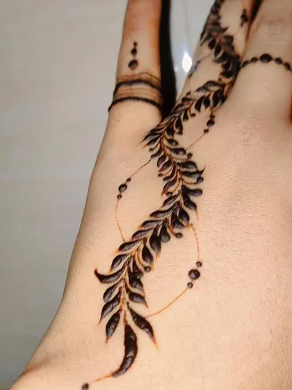 Another angle of the self-love henna, showing how it gracefully follows the curve of the hand.