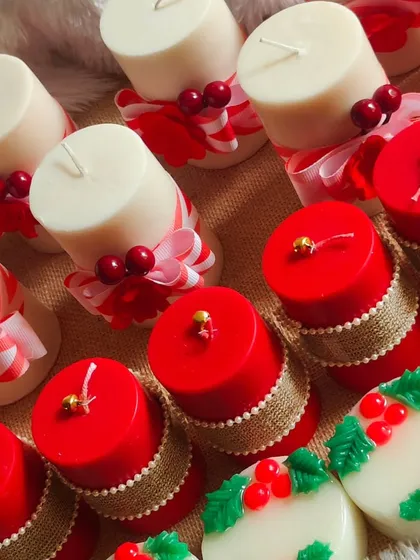 A close-up of the festive red and white pillar candles and holly-themed soaps.