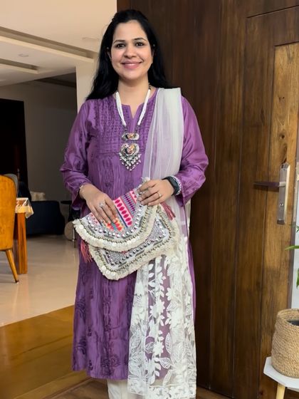 This purple Chikankari kurti is styled with a statement silver necklace and a beautiful embroidered clutch, showing how accessories can elevate a simple kurta.