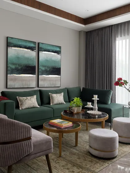 This cozy lounge corner features a deep emerald green sectional sofa, paired with abstract art and layered textures. It's a perfect example of how we create comfortable, stylish nooks for relaxation.