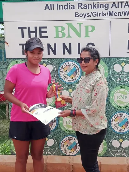 Reva Rana, an unseeded player, proudly accepts her trophy after reaching her first AITA CS National U-14 finals. Her journey to the final included defeating the second-seeded player.