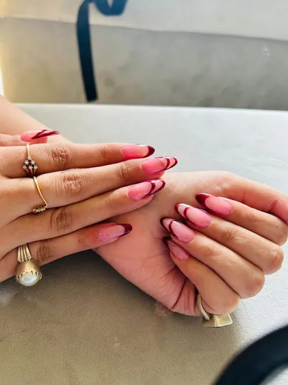 A side view of the deep red French manicure, highlighting the precision of the curve.