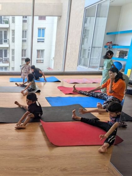 A wider view of our yoga and flexibility class, with students of different ages practicing together in a bright, open studio.