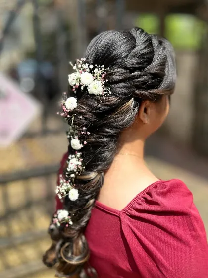 A messy mermaid hairstyle decorated with fresh baby's breath and small white flowers for a soft, bohemian look.