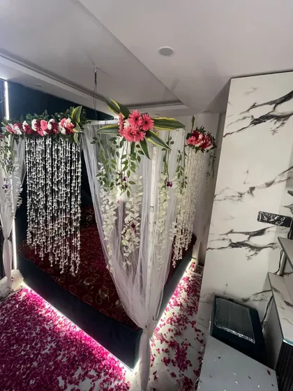 A side view of the floral canopy, showcasing the mix of fresh flowers and hanging greenery.