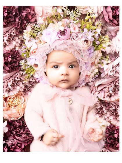 A 3-month-old baby surrounded by a bed of flowers. This artistic and beautiful setup creates a truly stunning and memorable portrait.