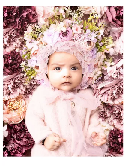 A 3-month-old baby surrounded by a bed of flowers. This artistic and beautiful setup creates a truly stunning and memorable portrait.