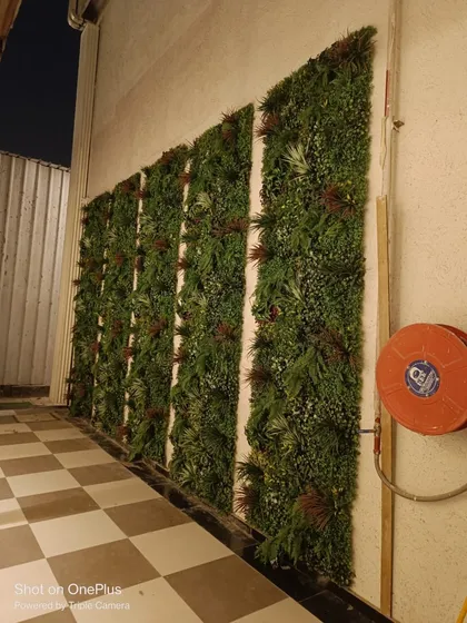 Vertical green panels installed along a narrow passageway, instantly adding depth and visual interest to an otherwise plain wall.