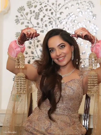 A playful and happy bride showing off her kalire and the beautiful mehendi stain on her hands.