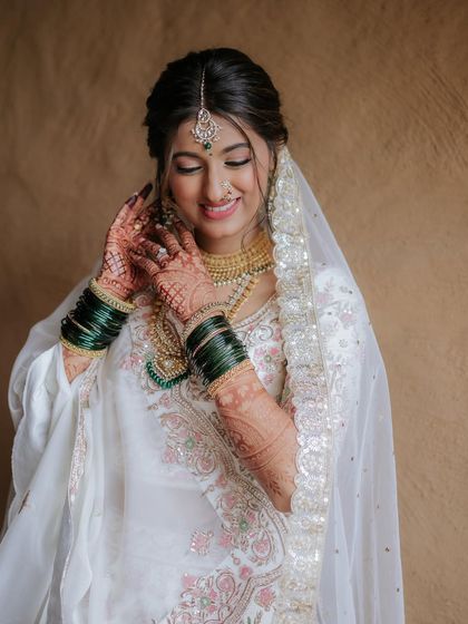 Another shot of her adjusting her jewelry, showing the complete look from a different angle.