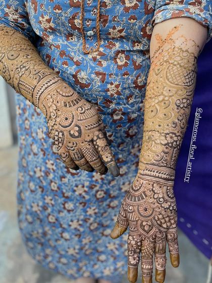 Full bridal mehendi for bride Neha, showcasing a mix of traditional Indian motifs and geometric patterns from her fingertips to her elbows.