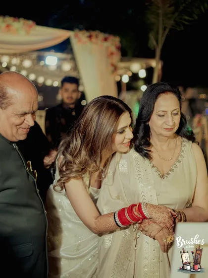 A wedding to remember. Here, the bride shares a special moment with her parents, adding their blessings to a custom wedding canvas.