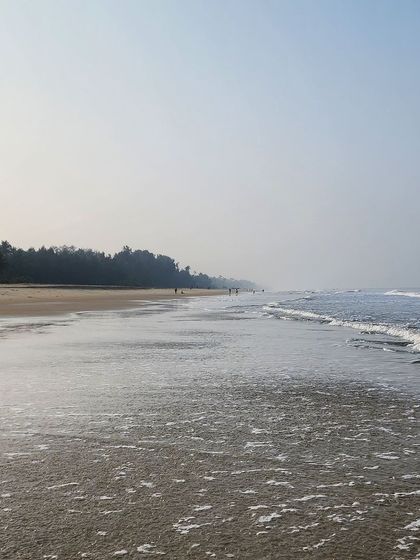 The serene beauty of the Konkan coast. Our West Coast Odyssey tour includes rides along quiet beaches like this, where you can enjoy the gentle waves and peaceful atmosphere.
