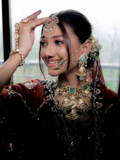 A beautiful close-up profile, highlighting the intricate nose ring, maang tikka, and statement necklace. Every detail is perfectly placed to create a majestic bridal look.
