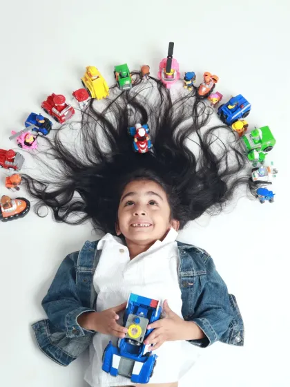 A creative pre-mundan shoot concept, where this little boy's amazing long hair is decorated with his favorite Paw Patrol toys.
