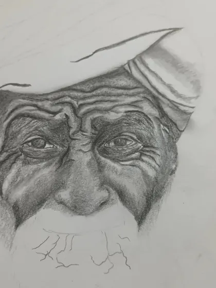 A close-up of the shading process on the face. You can see the careful pencil work required to create the texture of aged skin and the intensity of the eyes.