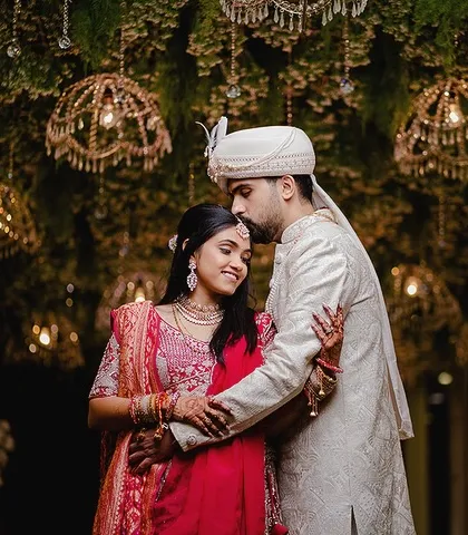 A romantic portrait under a beautifully decorated ceiling. The groom's forehead kiss and the magical ambiance create a fairytale moment.