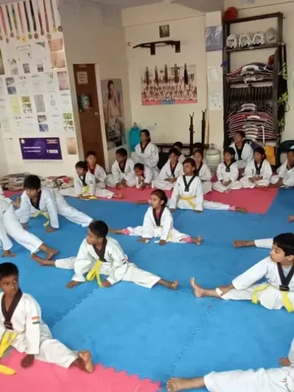 A group of yellow belts working on their splits. We build a strong foundation of flexibility from the very beginning.