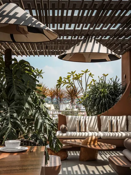 A view from the outdoor dining area looking towards the lounge. The space is designed to feel open and connected, encouraging easy movement and interaction between the different entertainment zones.
