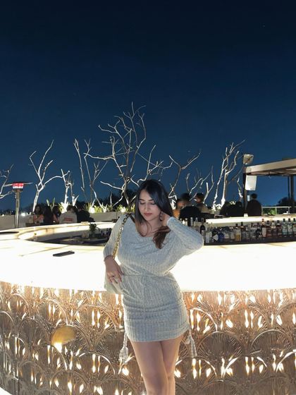 A shot of the knit dress at the bar. This sets the scene and shows the outfit in a typical night-out environment.