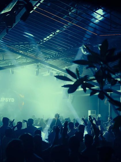 An atmospheric shot of the crowd at Xora, with smoke and moody lighting creating a cinematic feel.