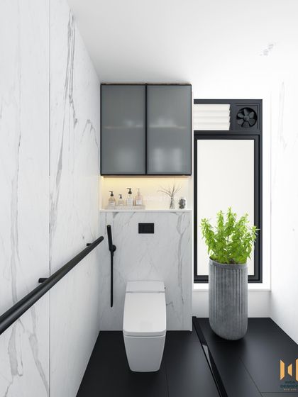 The WC area in the modern bathroom, featuring a wall-mounted toilet, a frosted glass cabinet for storage, and a large potted plant for a touch of green.