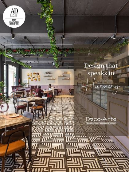 Design that speaks in harmony. This cafe interior is a timeless blend of textures, colours, and ambiance, curated for an unforgettable experience with its geometric floor tiles and hanging greenery.