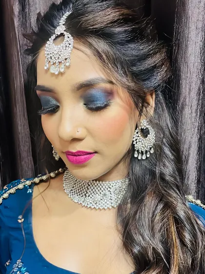 This is a complete reception makeup look I created for a client. The style features a dramatic blue smokey eye balanced with a bold pink lip, complemented by elegant hairstyling and traditional jewelry. My goal for any event makeup is to create a stunning, memorable look that lasts all night.