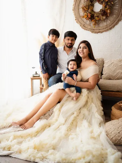 A beautiful family of four, with the mother's stunning dress adding a touch of drama and elegance.
