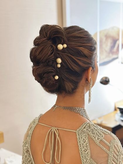 Another angle of the textured updo with pearls, showing how it complements the back of the intricately designed blouse.