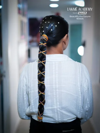 A sleek, long braid with creative thread work and embellishments. This style shows how to combine traditional techniques with modern, artistic touches.