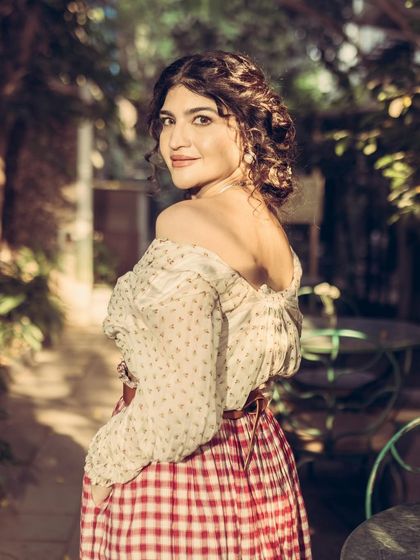 An over-the-shoulder look from the same series, showcasing the off-the-shoulder top and the soft, romantic hairstyle.