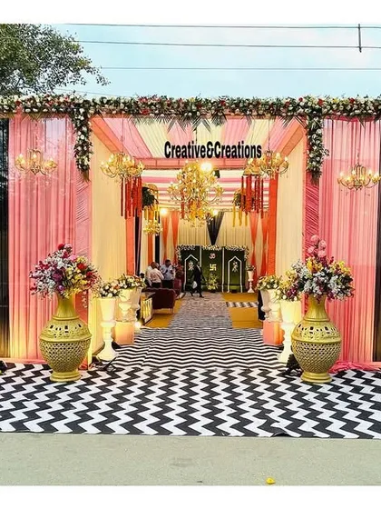 For the modern couple, I created this chic and stylish wedding entrance. The bold black and white chevron floor, paired with soft pink draping and elegant chandeliers, offers a contemporary twist on classic wedding decor.