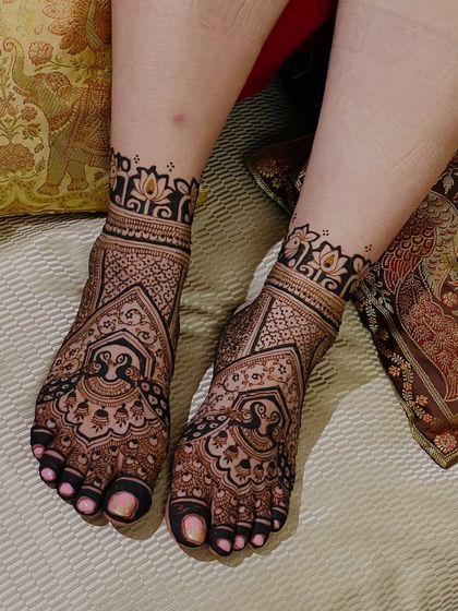 A dense and detailed foot design featuring peacock figures within an architectural frame, perfect for a traditional bridal look.