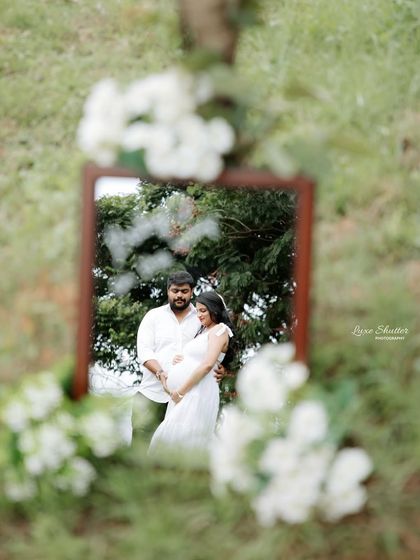 A creative reflection shot during an outdoor session. Using a mirror in nature adds an artistic and unexpected element to your maternity photos.