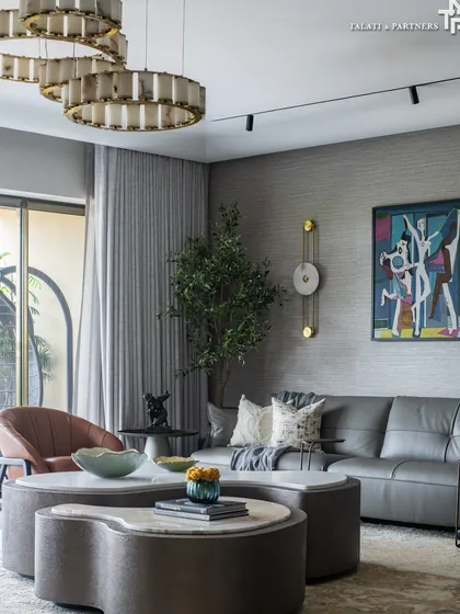 In this Ashford Apartments residence, the design exudes modern sophistication, blending sleek lines with luxurious textures. While the backdrop remains muted with elegant greys, accents of glam shine through the sculptural chandeliers and brass detailing.