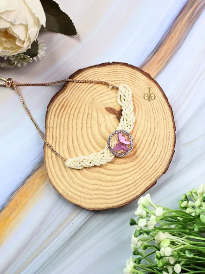 A close-up of our butterfly Lumba Rakhi, featuring an adjustable gold chain and pearl details for an elegant finish.