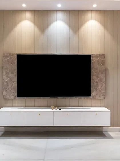 A modern living room with a floating white TV console set against a beige, textured wall. The soft curtains and plush sofa create a comfortable and elegant space for entertainment.