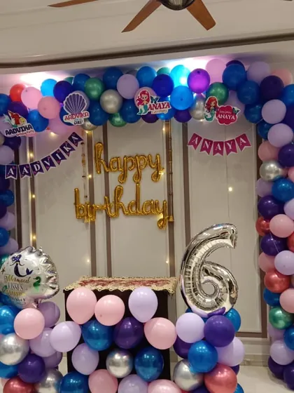 This Mermaid theme for a 6th birthday shows how I can adapt themes for different ages. The large balloon arch frames the party space, with a custom name banner and a number '6' foil balloon.