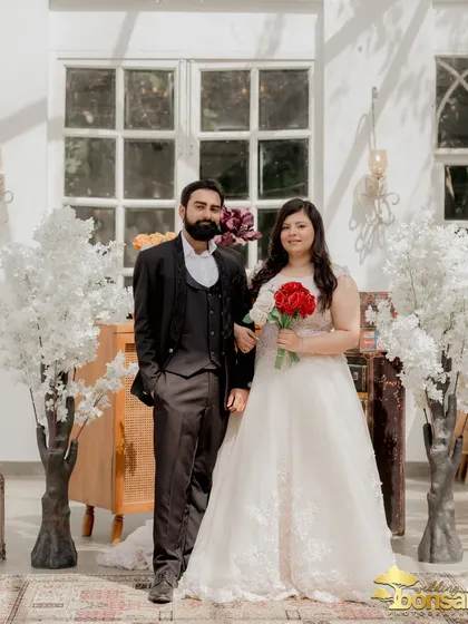 A formal portrait of the couple, showcasing their elegant attire against the backdrop of white cherry blossoms at Picture Villa.
