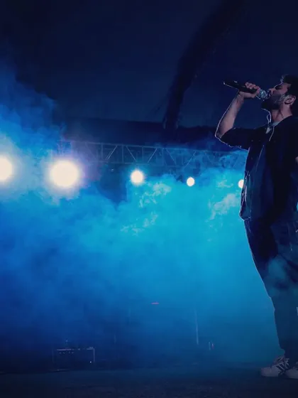 On stage, under the lights, sharing stories through music. This is my happy place. This shot captures the feeling of performing for a large audience, perfect for when your event needs that big concert vibe.