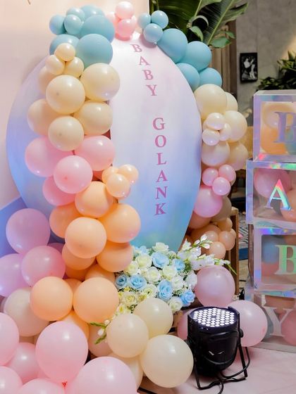 Personalization is key. For this event, I designed a custom 'Baby Golank' sign surrounded by pastel balloons and iridescent 'BABY' blocks, making the decor feel truly special and unique.