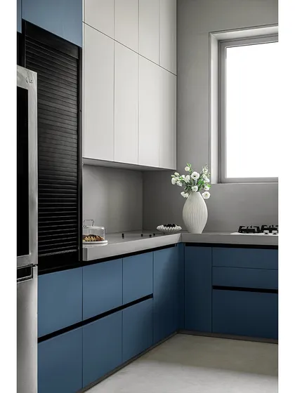This modern kitchen features matte blue and white cabinetry for a serene and sophisticated atmosphere. The grey countertop and backsplash provide a subtle contrast, creating a calm and stylish space perfect for a contemporary home.