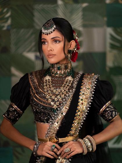 A close-up of the regal black and gold look, showing the intricate detail of the jewellery and the powerful, defined eye makeup.