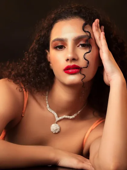A close-up beauty shot from the same series, focusing on the model's striking features and the intense red lighting.