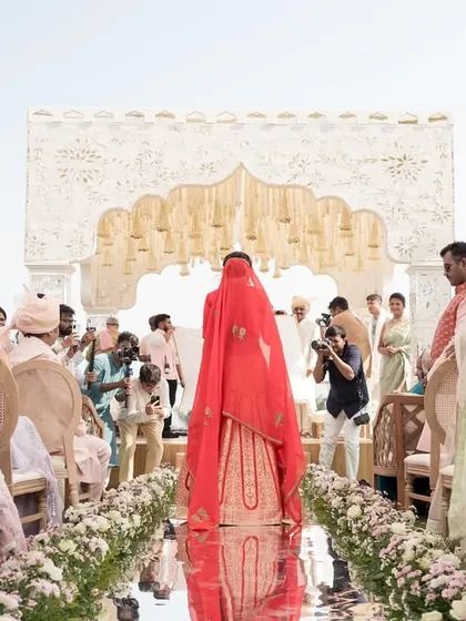 The bride's grand entrance on a reflective mirror aisle, creating a stunning visual as she walks towards the mandap.