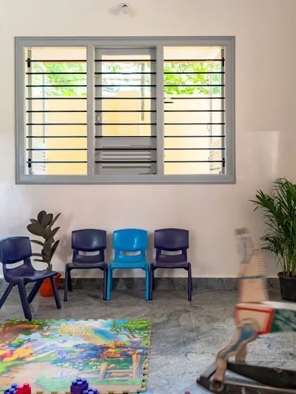 The activity zone is kept bright and airy with large windows that allow for cross-ventilation. This passive cooling strategy significantly reduces the indoor temperature, creating a comfortable space for children to eat, rest, and play without relying on artificial energy.