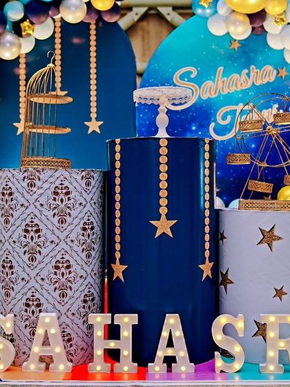 A "Twinkle Twinkle Little Star" themed fourth birthday. The deep blue and gold decor features star-themed plinths, a galaxy backdrop, and a large light-up number '4'.