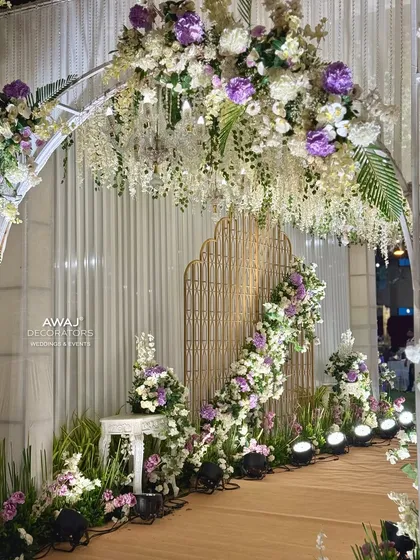 A peek through the floral archway, revealing a beautifully decorated path with intricate golden screens.